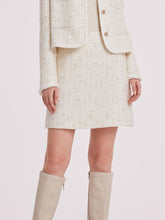 A lady wears a white mini skirt.